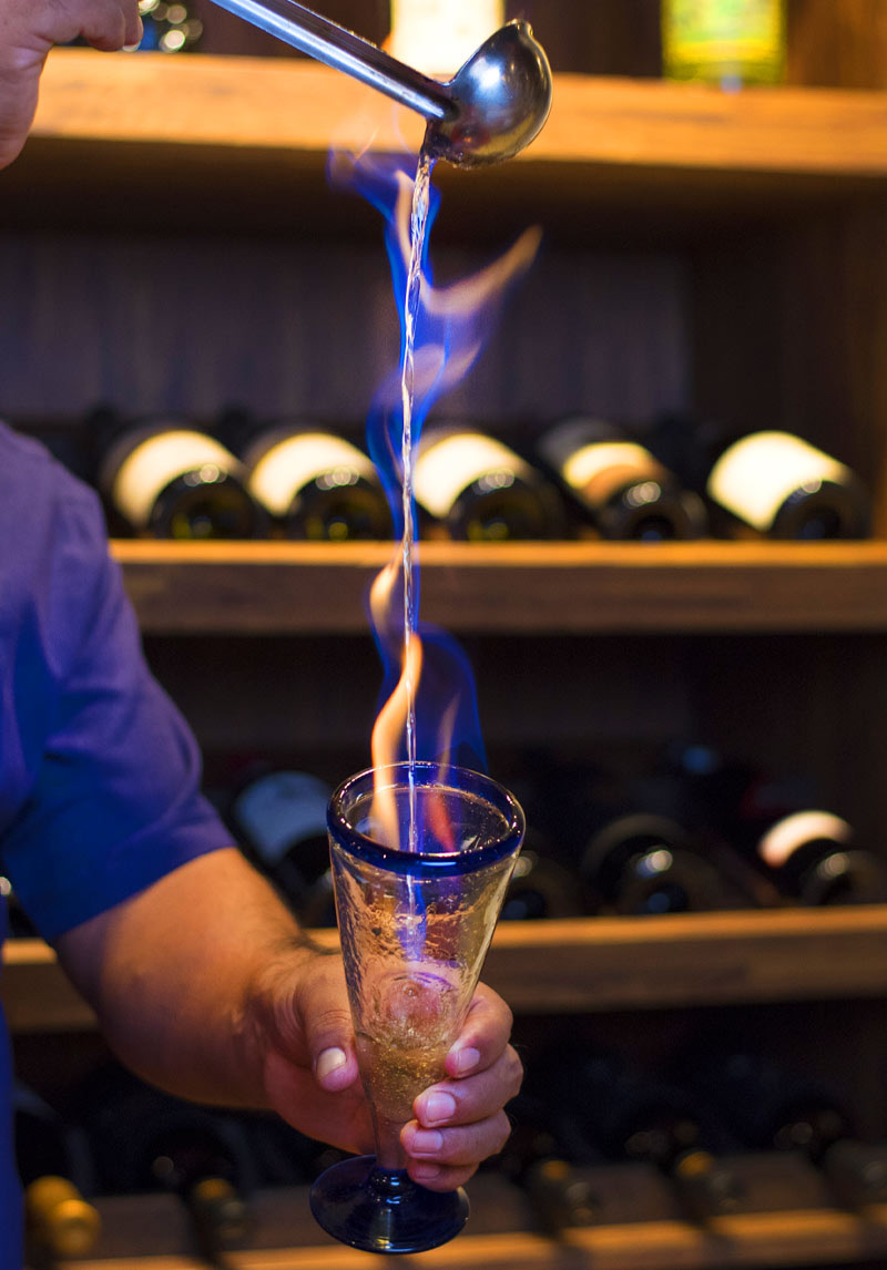 Bartender pouring a flaming cocktail